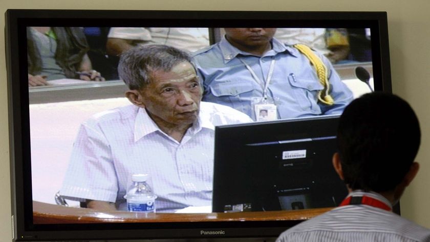 A man watches the live feed of the trial of chief Khmer Rouge torturer Kaing Guek Eav