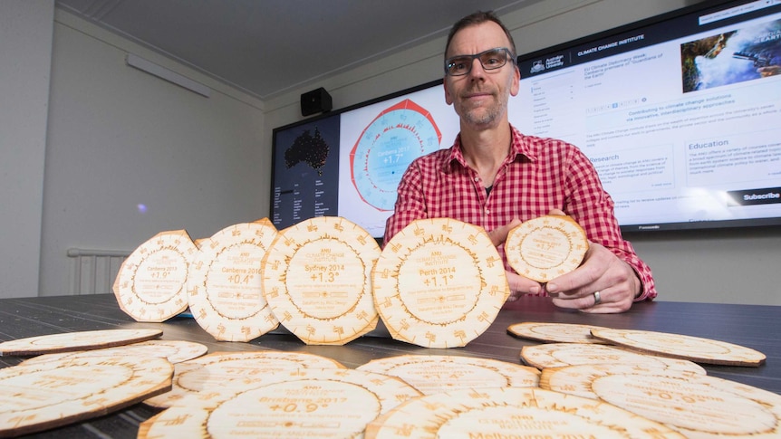 Doctor Geoff Hinchcliffe holds up a 3D printed climate drink coaster