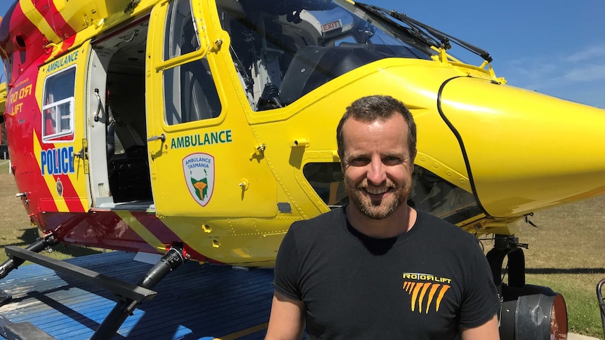 Helicopter pilot Chris Fahey standing in front of the Tasmanian rescue helicopter