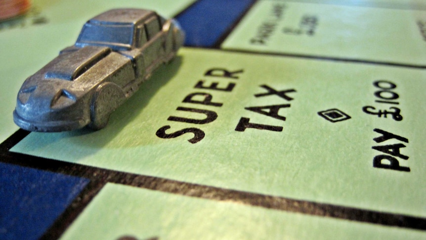 Close-up of a car figurine on a Monopoly board, landing on the "Super tax" square.