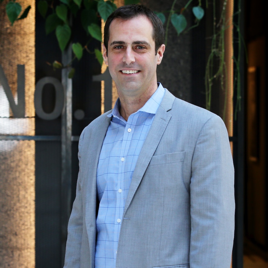 Sezzle CEO Charlie Youakim standing in a suit in front of a building.