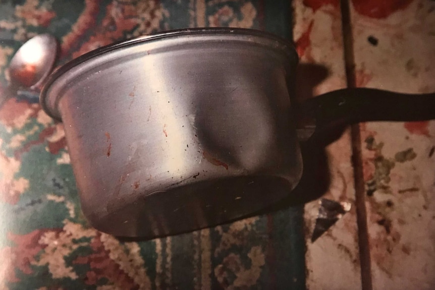 Dented and apparently blooded kitchen pan.