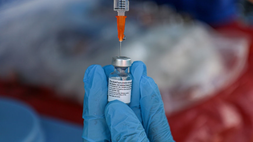 Nurse draws Pfizer vaccine into syringe