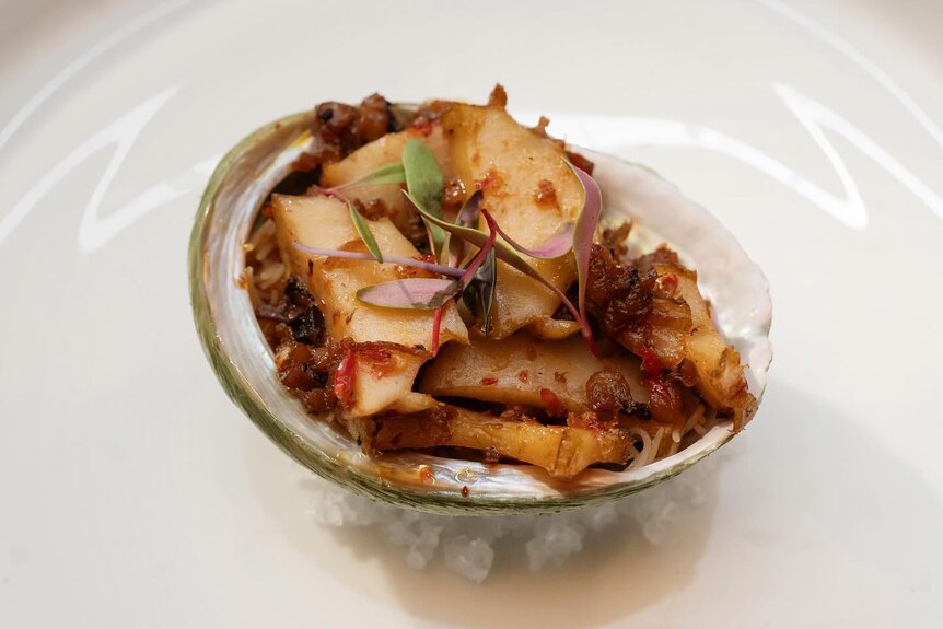 Strips of cooked abalone mixed with XO sauce served in an abalone shell