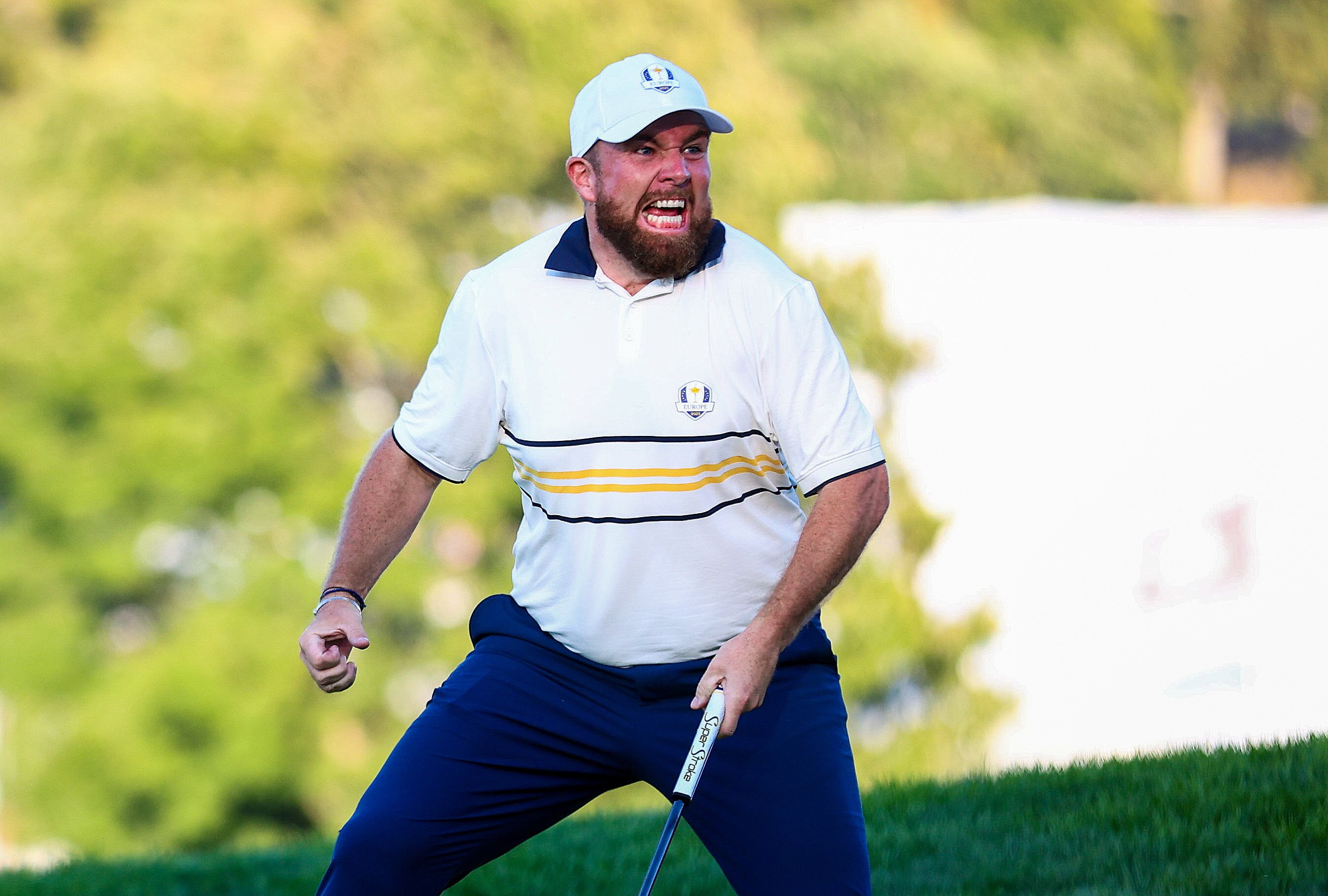Shane Lowry screams with joy and pumps his fist after making a putt