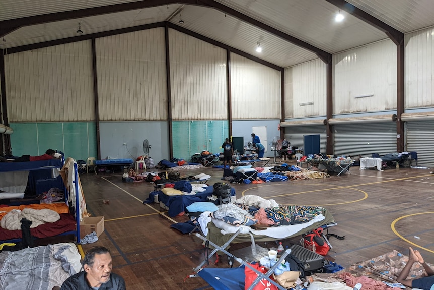 people lay on stretches inside an evacuation centre