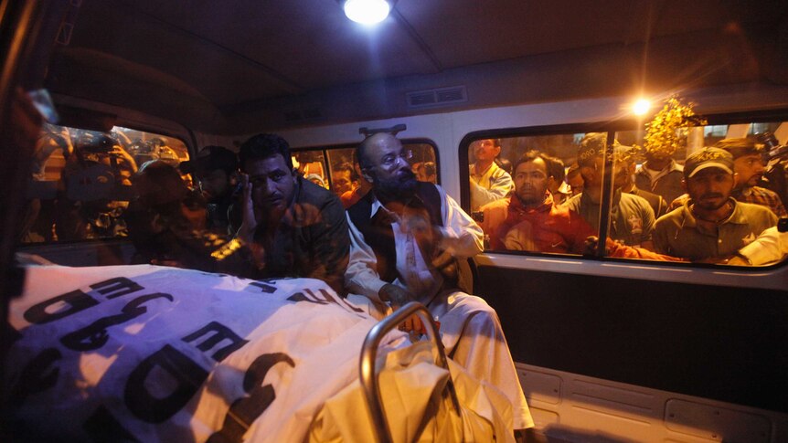 Mourners gather around the body of Chaudry Aslam