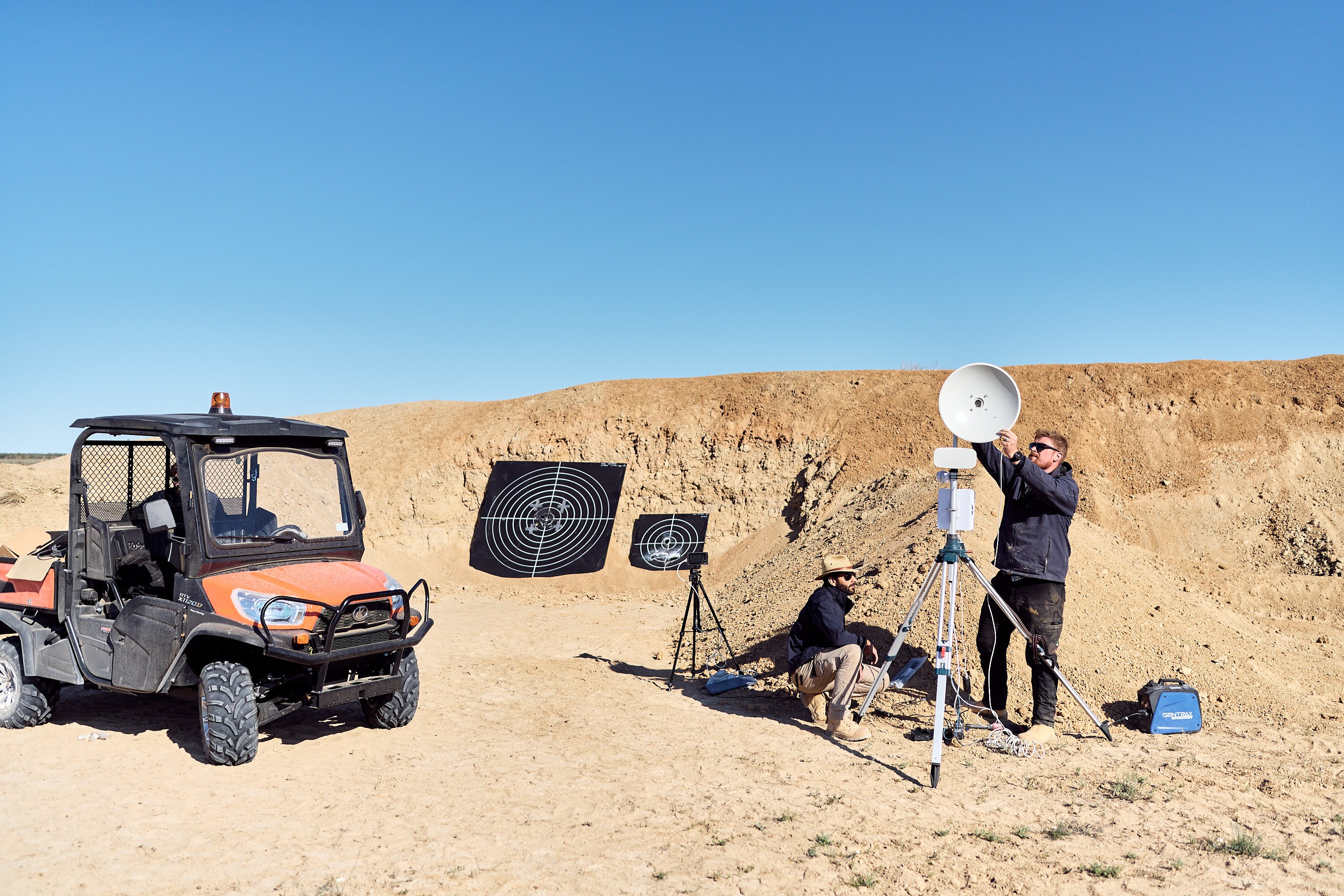 Quad bike next to laser technology in desert setting 