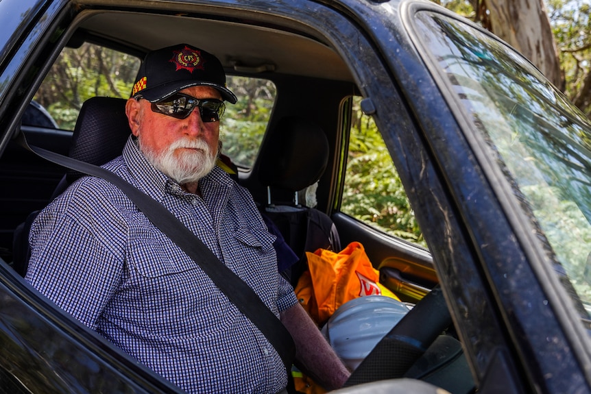 A man wearing a CFS hat sits at the wheel of a car.