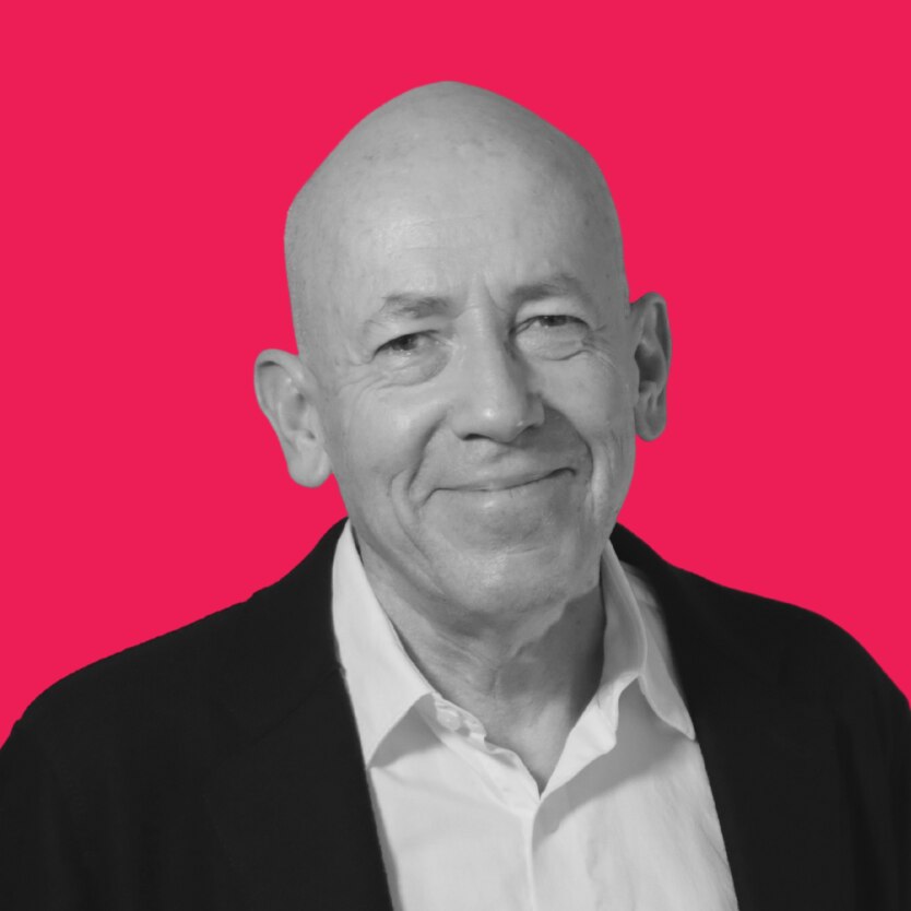 Black and white photo of Morris Gleitzman in front of a pink background 
