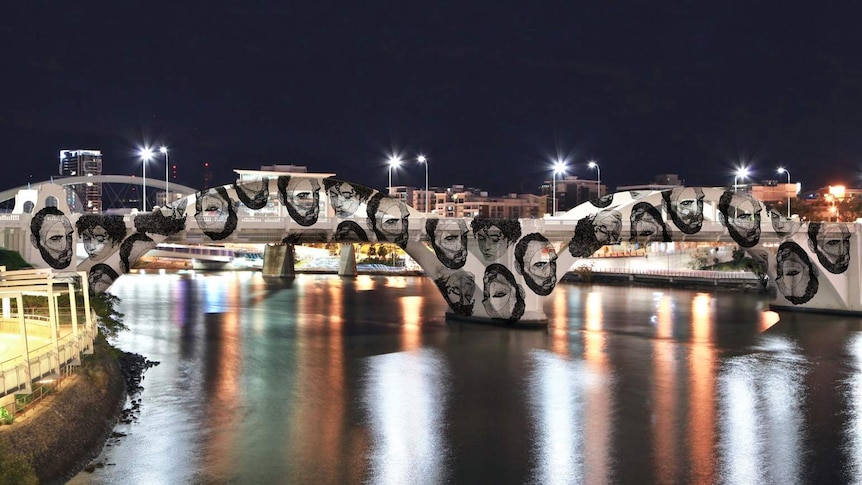 The William Jolly Bridge is lit up white with a projected image.