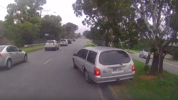 A screenshot of the video showing the car swerving, accelerating, stopping, before reversing on a busy road.