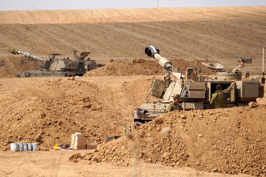 Two tanks in dirt, seen from a distance.