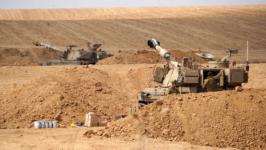 Two tanks in dirt, seen from a distance.