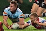 Jack Williams and Matt Dufty dive towards a rugby ball with their eyes closed and arms out