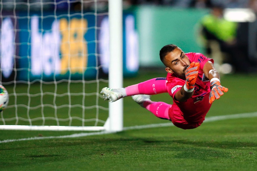 Mark Birighitti stretches to make a save