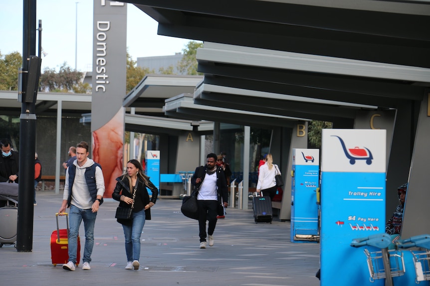 Pasajeros caminando afuera de la entrada nacional al aeropuerto de Perth.