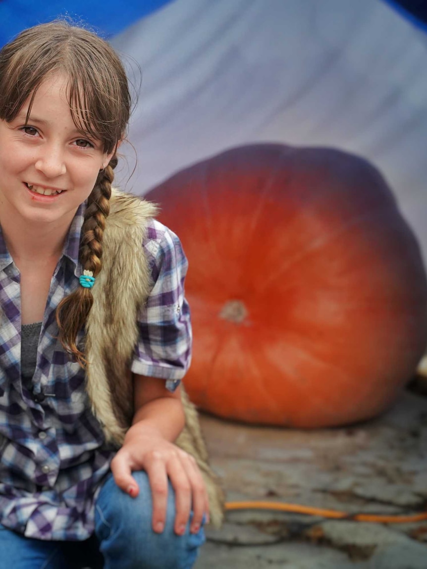 Rhianna McKnight in front of her friend's giant pumpkin