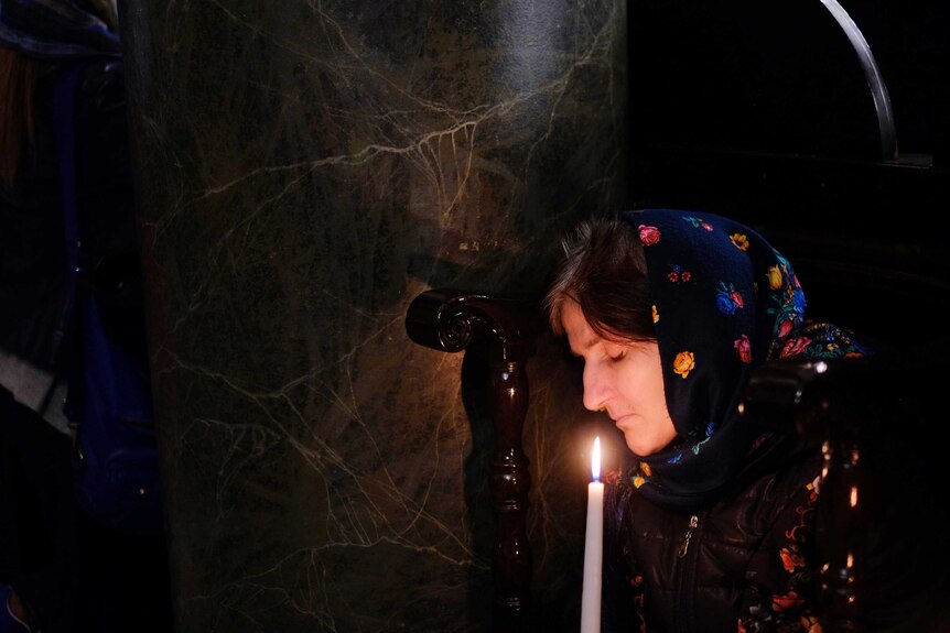 A woman holds a candle during the Easter resurrection service