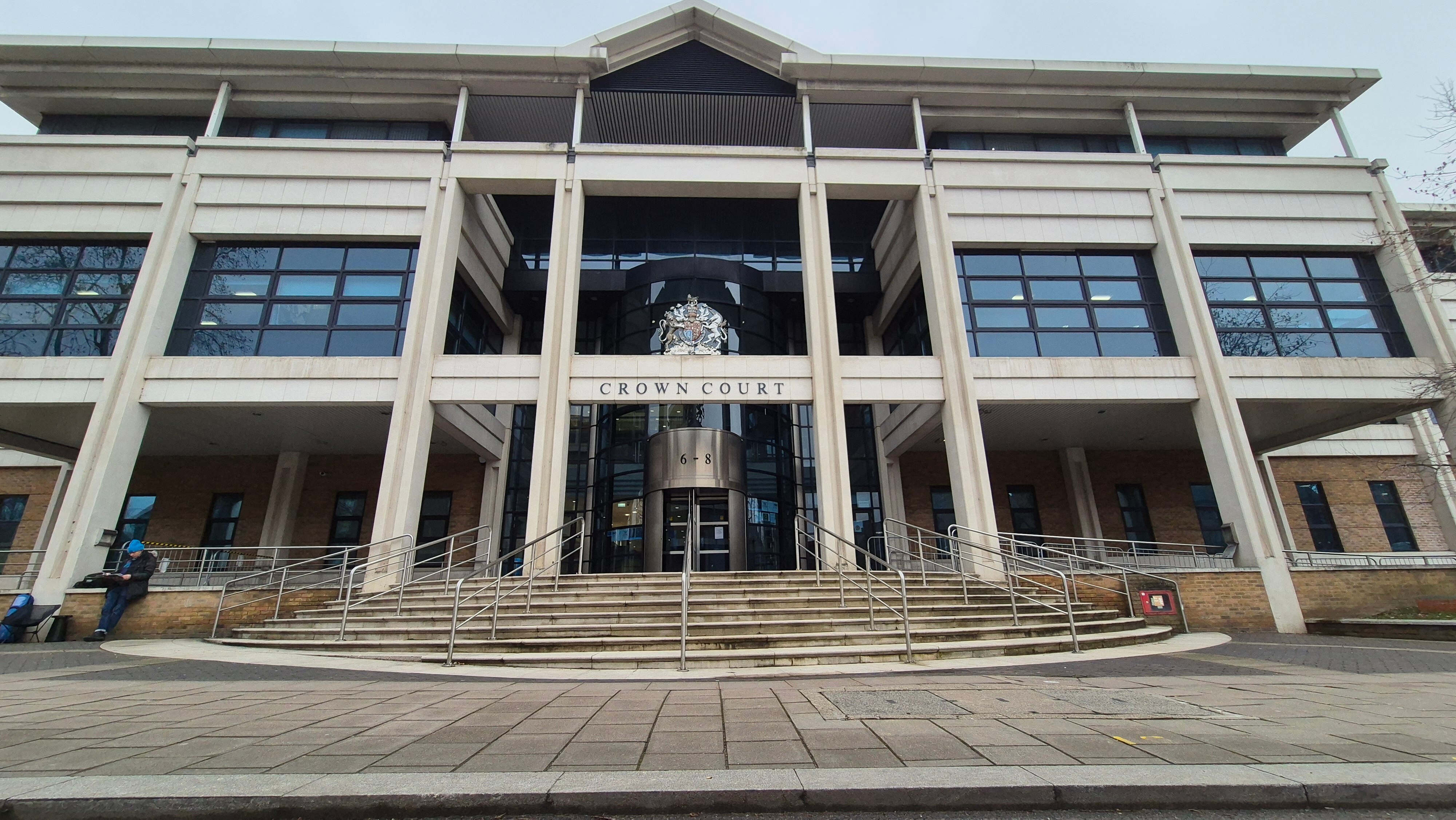 A large double-storey court building with stairs leading to the front door from the footpath