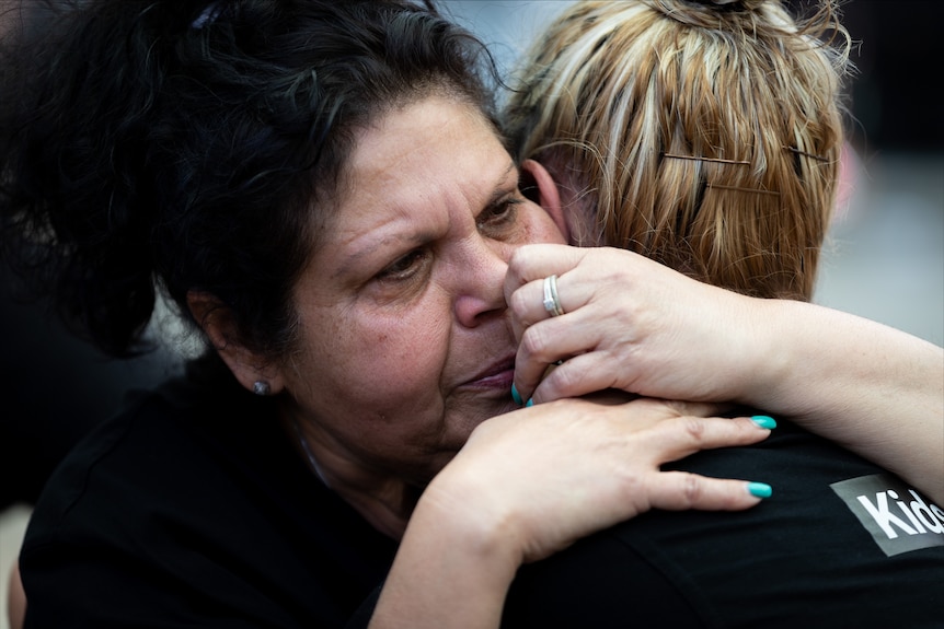 Cassius's mother Mechelle Turvey hugs a woman at the rally.