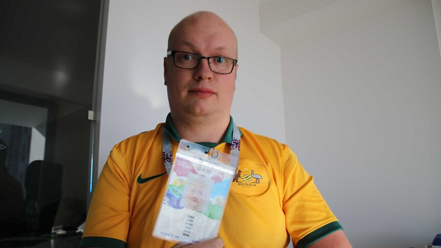 Socceroos fan Aaron Camm holds his Russia 2018 Fan ID