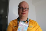 Socceroos fan Aaron Camm holds his Russia 2018 Fan ID