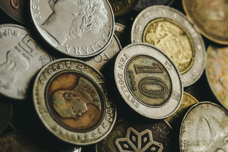 A close up of a pile of coins of different denominations from a range of currencies. 