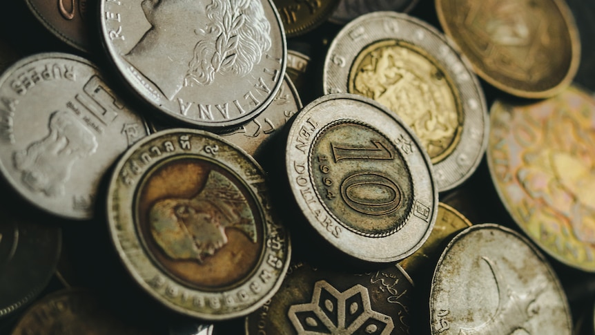 A close up of a pile of coins of different denominations from a range of currencies. 