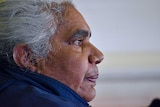A close up of an Aboriginal woman.  She has white hair and tears in her eyes.