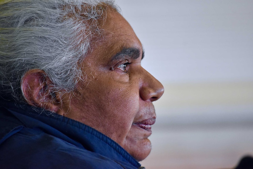 A close up of an Aboriginal woman.  She has white hair and is staring into the distance