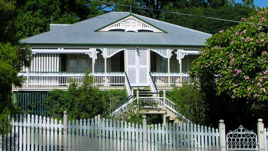 Queenslander house with a white picket fence.