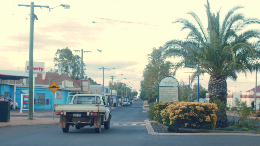 A ute drives down a regional town's main street.