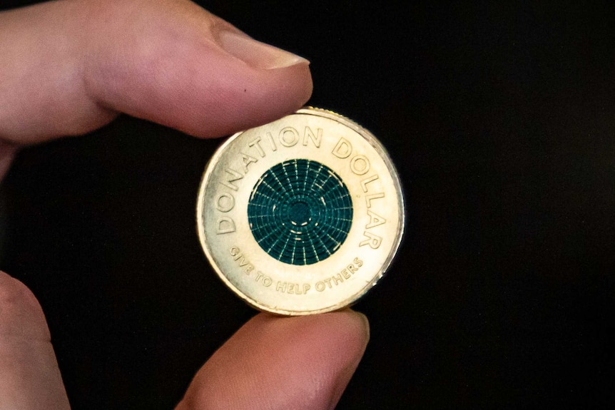 A close-up image of a gold coin with a green centre.