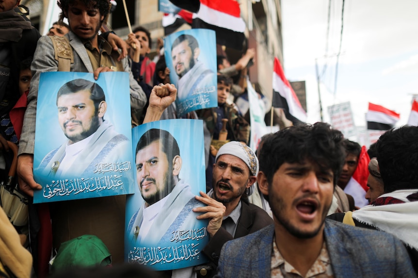 Supporters of Yemen's Houthis hold posters of top Houthi leader Abdul-Malik Badruddin al-Houthi during a rally.