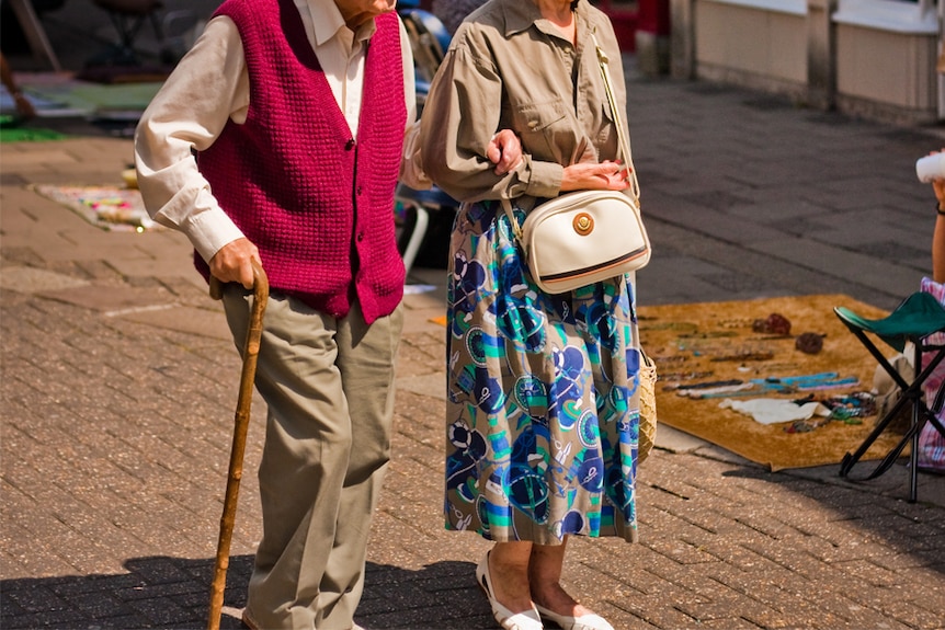 An elderly couple going for a walk.