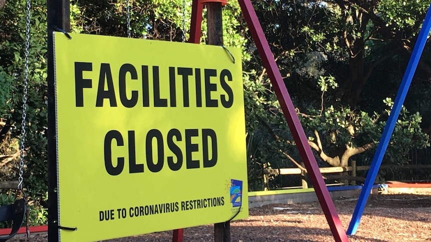 A playground with a 'facilities closed' sign on it.