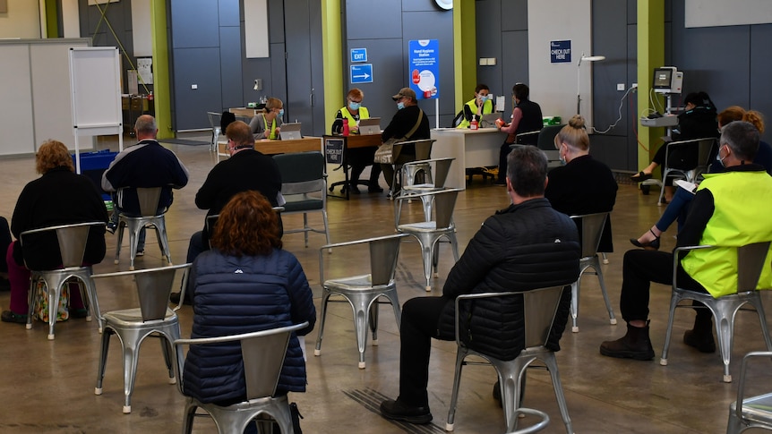 A waiting area in a municipal building, with people sitting in a socially distanced configuration.
