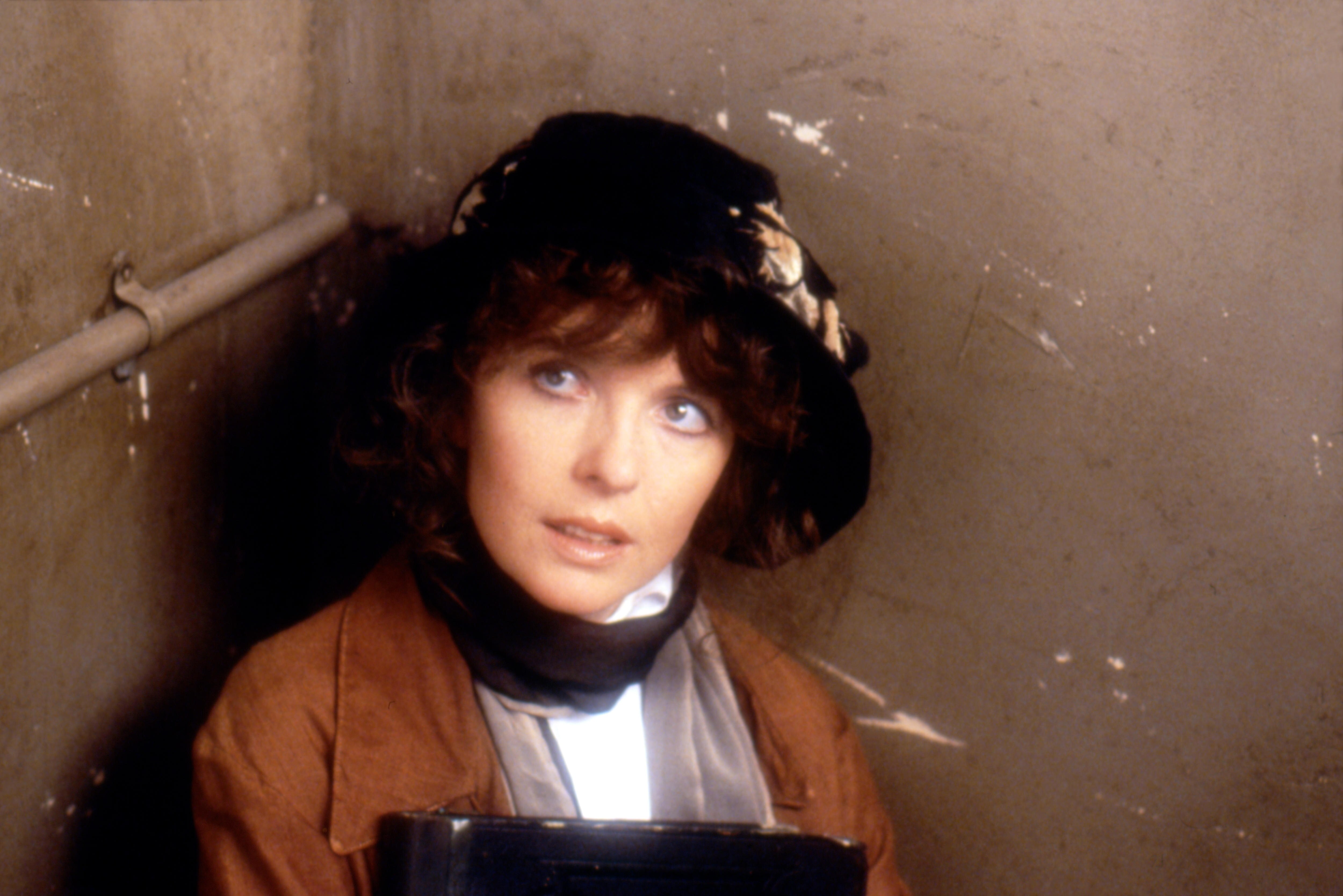 A woman in a black hat staring up. 