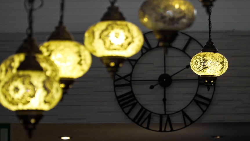 A wall clock and ornamental light fittings