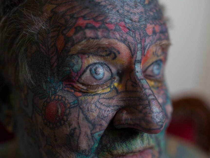 Close-up of John's heavily tattooed face