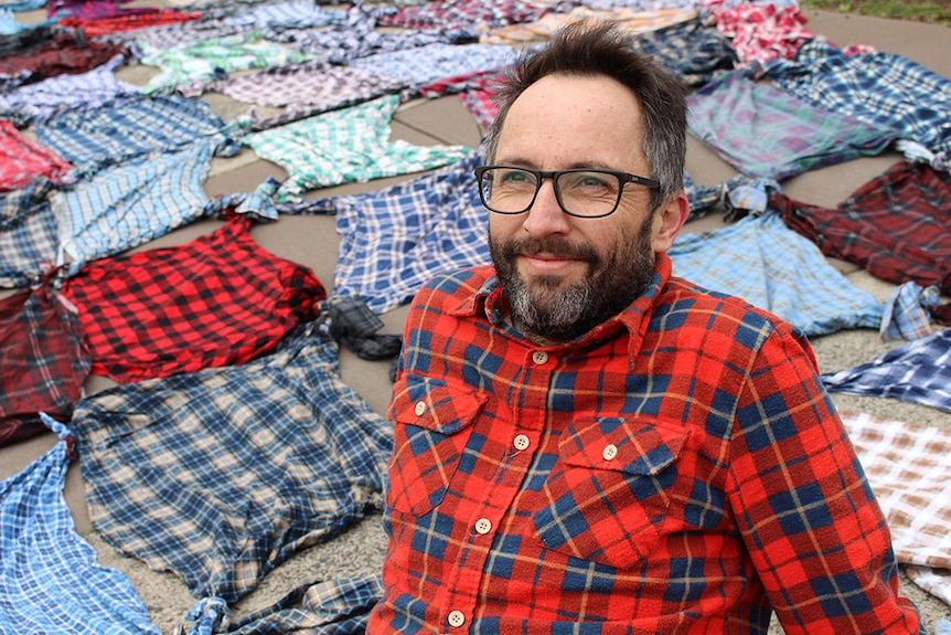 Adrian Smith sits among flannelette shirts