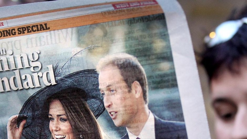 A woman reads a copy of the Evening Standard outside Clarence House