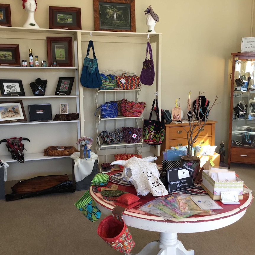 The inside of a shop stocked with handbags, jewellery and art.