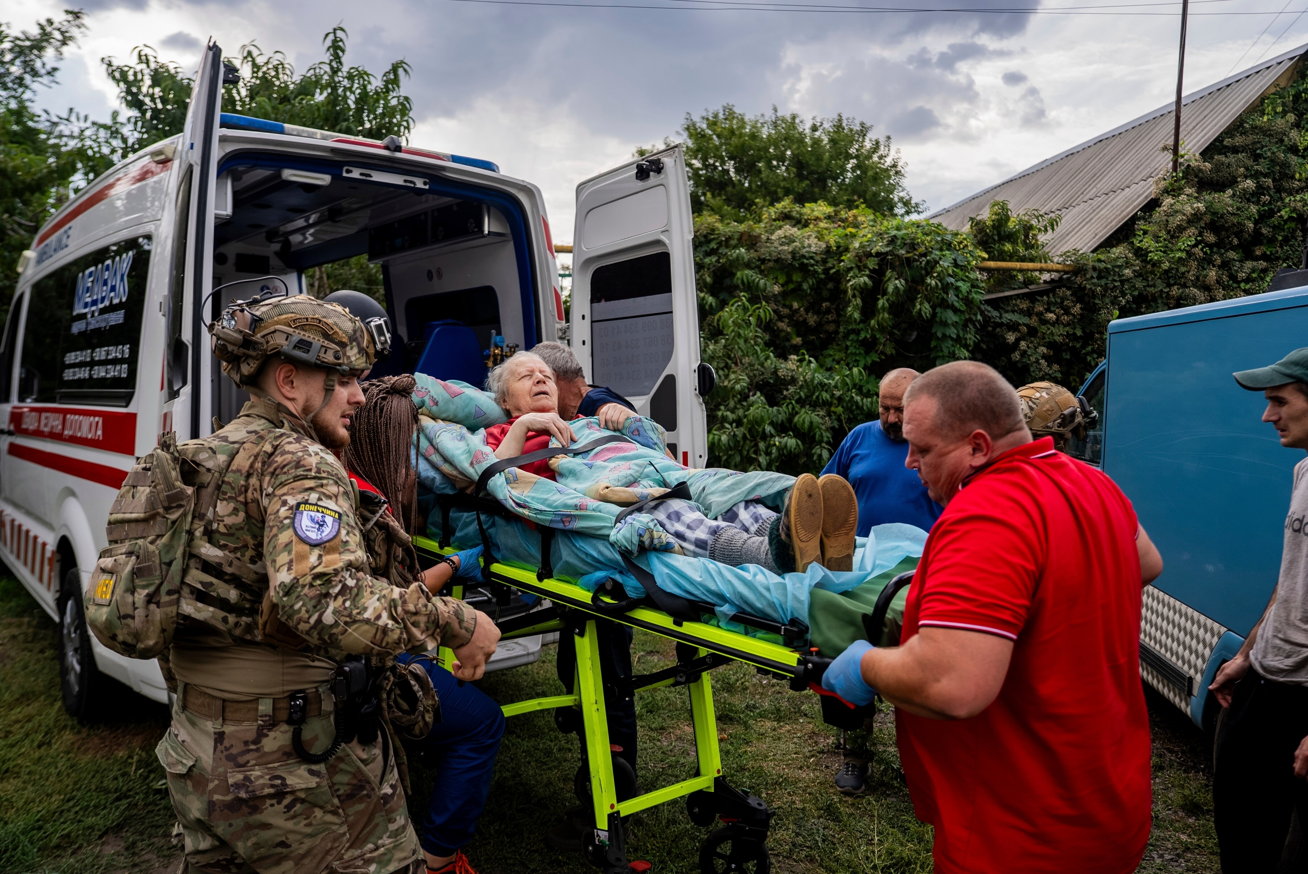 A woman is carried on a stretcher into an ambulance. 