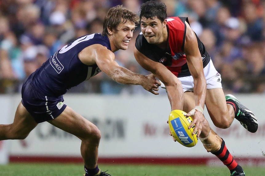 Patrick Ryder of the Bombers tries to escape from the Dockers' Matt De Boer.