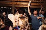 Young people partying inside a wooden cabin