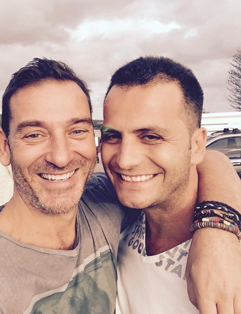Two men taking a selfie and smiling for the camera