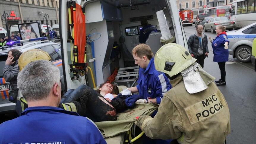 An injured woman is put into an ambulance after a subway blast in Russia