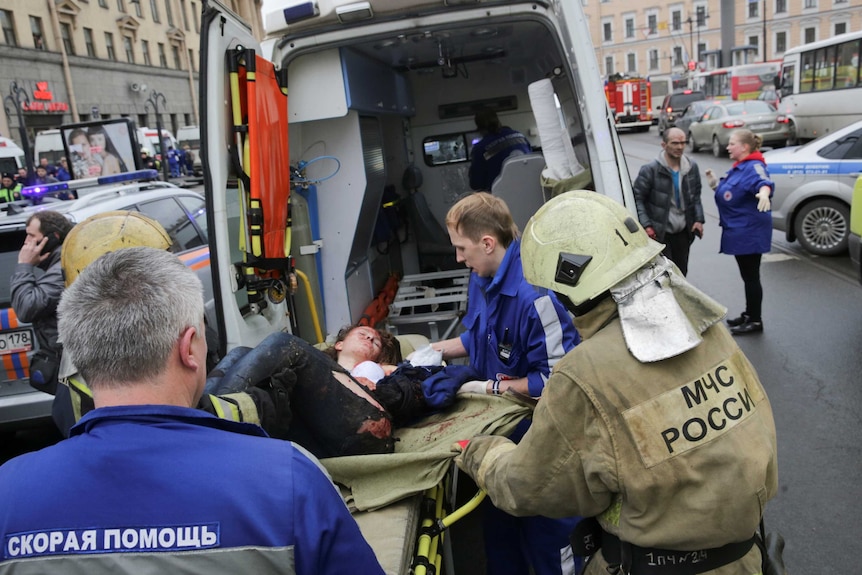 An injured woman is put into an ambulance after a subway blast in Russia